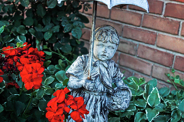 Garden Statue Holding Umbrella in Flowers stock photo