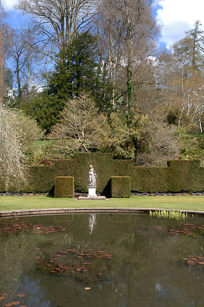 Garden Statue Garden statue in formal gardens with spring flowering shrubs yew lake stock pictures, royalty-free photos & images