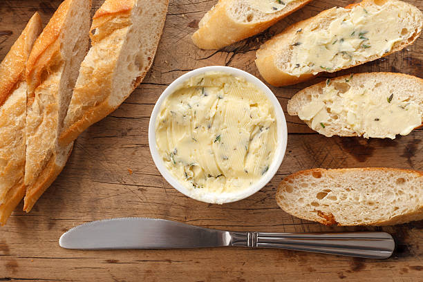 garlic bread compound butter herb baguette thyme rosemary coriander oregano stock photo