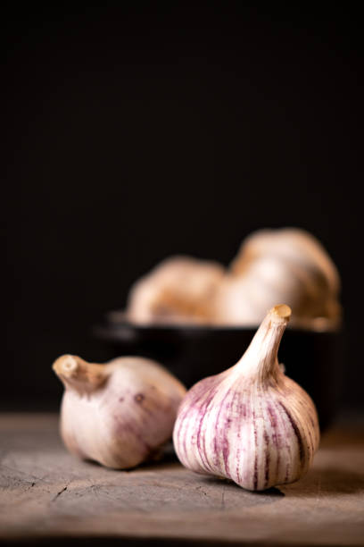 Garlic on a rustic old wooden board. stock photo