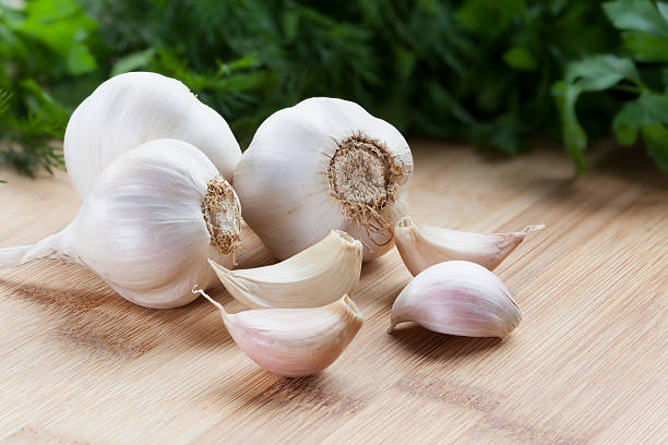 Garlic Garlic on cutting board. garlic stock pictures, royalty-free photos & images