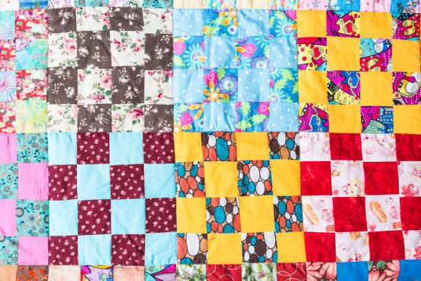 garment manufacturing, applique, home atmosphere, cosiness, traditions, sewing concept - beautiful textile field sewed of great nomber of squares in various colores and with different prints stock photo