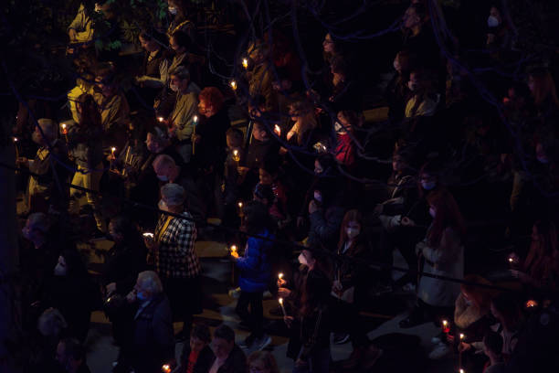Gathered crowd holding candles at night. stock photo