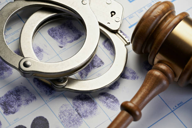 Gavel and handcuffs on fingerprints: Arrest crime concept stock photo