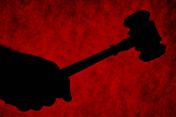 Gavel Hand holding a gavel in silhouette against a red grungy background. repression stock pictures, royalty-free photos & images