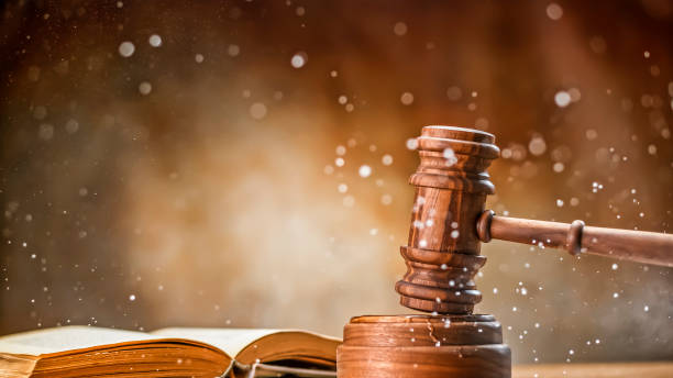 Gavel with law book Wooden gavel with open law book and splashing water on table. judgement stock pictures, royalty-free photos & images
