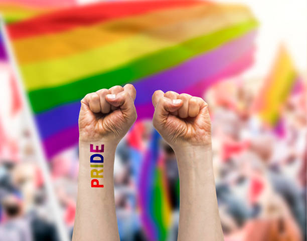 la mano de un gay con un tatuaje que dice orgullo - nyc pride parade fotografías e imágenes de stock