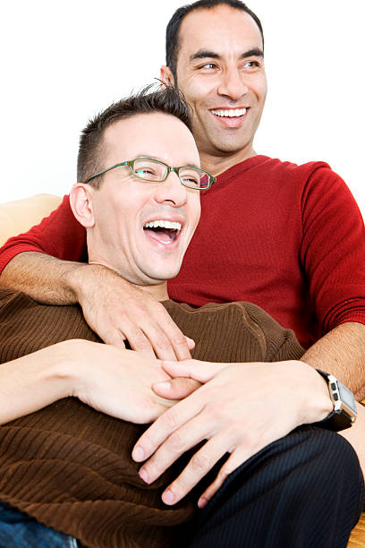 gay lifestyle: carefree A light-hearted moment from a gay mixed-race couple enjoying time together. gay spooning stock pictures, royalty-free photos & images