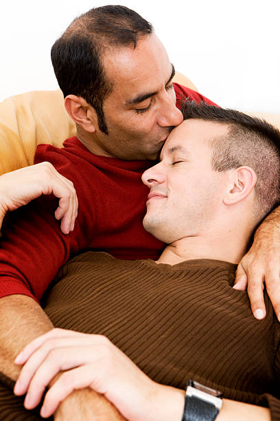 gay lifestyle: security A moment of candid intimacy between a loving gay couple. gay spooning stock pictures, royalty-free photos & images