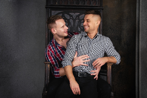 ✓ Imagen de Retrato de la pareja gay guapo con una sonrisa a la cámara como  el otro está a punto de besar su mejilla Fotografía de Stock