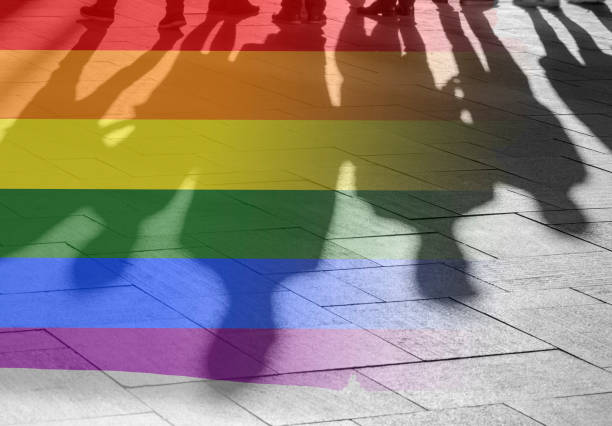 Gay Rights Shadows of People and Rainbow Flag as Symbol Right, Freedom - conceptual Picture about anonymous Gay Lesbian and Transgender in the World stock photo