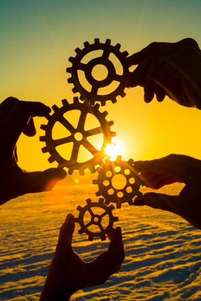 gears in the hands of a group of people. stock photo