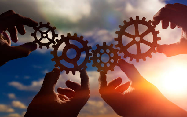 gears in the hands of people against the sky. stock photo