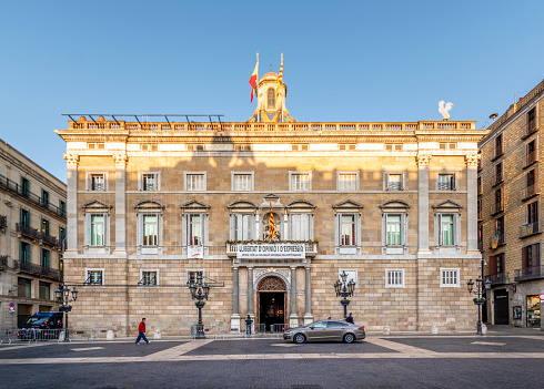 December 14, 2021 - Barcelona, Spain: People standing in front of the Facade of Catalunya Generalitat palace in Sant Jaume square, Barcelona, Spain, an winter morning. This palace is the head office of the Presidency of the catalan government .