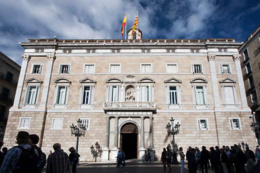Barcelona,Spain-october 22, 2012: People standing in front of the Facade of Catalunya Generalitat palace in Sant Jaume square, Barcelona, Spain, an autumn afternoon. This palace is the head office of the Presidency of the catalan government .