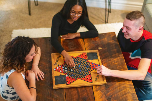 Generation Z Multiracial Group of Friends Cooking Playing Playing Chinese Checkers Relaxing and Communicating in Modern Home Photo Series Playing Chinese Checkers in Western USA Generation Z Mixed Ethnicity Group of Friends Cooking Playing Relaxing and Communicating in Modern Home Matching 4K Video Available (Shot with Canon 5DS 50.6mp photos professionally retouched - Lightroom / Photoshop - original size 5792 x 8688 downsampled as needed for clarity and select focus used for dramatic effect) eyecrave stock pictures, royalty-free photos & images