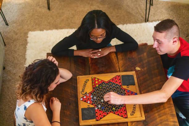 Generation Z Multiracial Group of Friends Cooking Playing Playing Chinese Checkers Relaxing and Communicating in Modern Home Photo Series Playing Chinese Checkers in Western USA Generation Z Mixed Ethnicity Group of Friends Cooking Playing Relaxing and Communicating in Modern Home Matching 4K Video Available (Shot with Canon 5DS 50.6mp photos professionally retouched - Lightroom / Photoshop - original size 5792 x 8688 downsampled as needed for clarity and select focus used for dramatic effect) eyecrave stock pictures, royalty-free photos & images