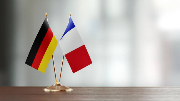 paire de drapeau allemand et français sur un bureau sur fond défocalisé - france allemagne photos et images de collection