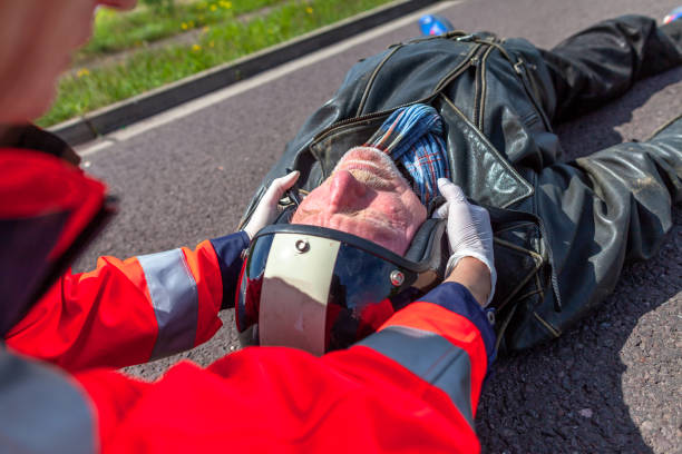 A german paramedic removes an helmet from an injured biker. Rettungsdienst is the german word for ambulance service. stock photo