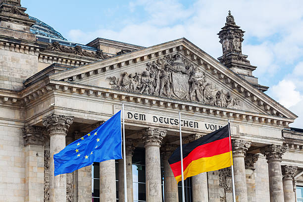 German Reichstag in Berlin, Germany German Reichstag in Berlin, Germany, with national flag bundestag stock pictures, royalty-free photos & images