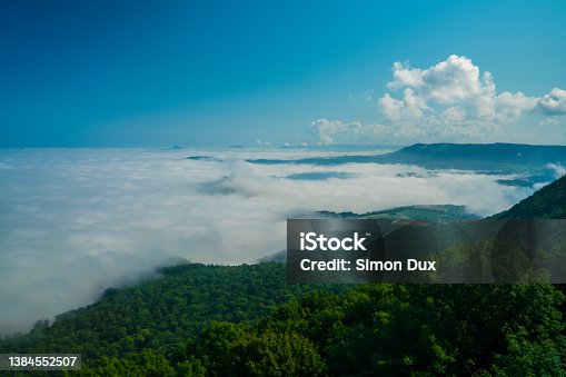 istock Germany, Magical panorama view above endless sea of fog clouds in valley of swabian alb mountains nature landscape on sunny day 1384552507