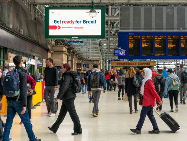 Get ready for Brexit sign in Glasgow Central station Glasgow, Scotland - Passengers in Central Station walking in front of a UK government sign advising people to prepare for Brexit. brexit stock pictures, royalty-free photos & images