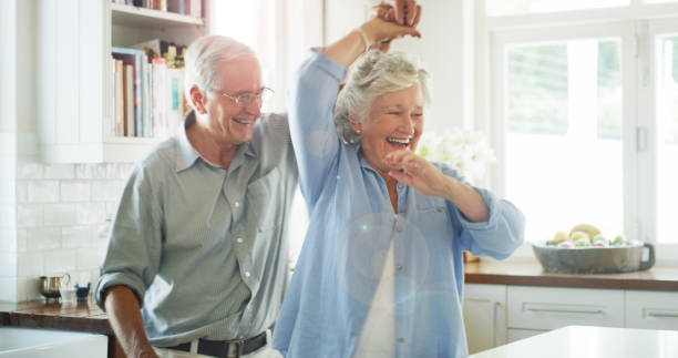 Get your groove back? Or never lose it at all Shot of a happy senior couple dancing together at home seniors stock pictures, royalty-free photos & images
