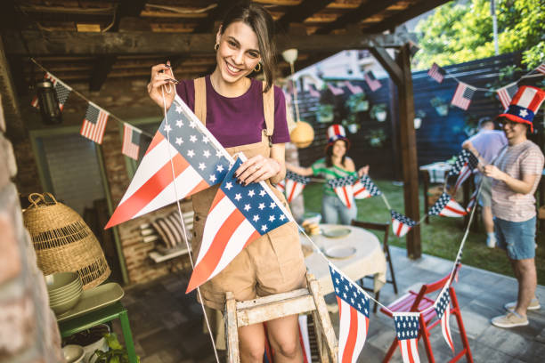 Getting ready for 4th July Photo of friends celebrating US Independence Day, decorating their back yard with American flags. decorations 4th of july stock pictures, royalty-free photos & images