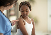 A child gets a bandaid put over their injection site in the doctor's office.