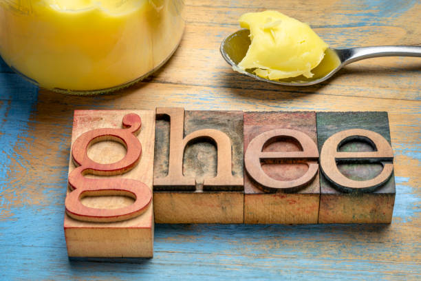 ghee in jar and spoon jar and  tablespoon of ghee (clarified butter) on grunge wood with a text in letterpress wood type ghee stock pictures, royalty-free photos & images