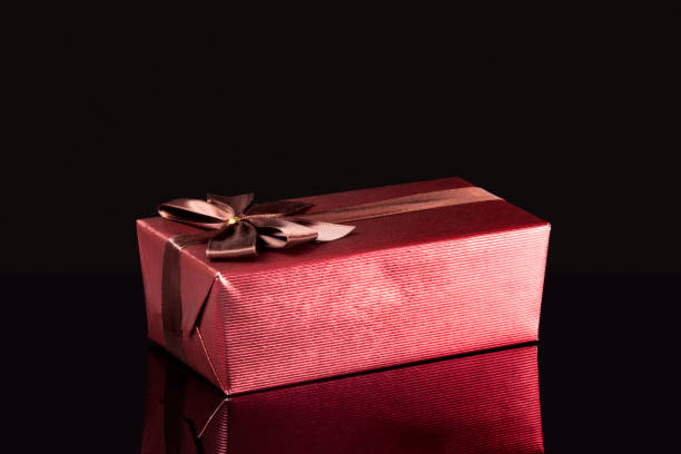 Gift box with its reflection on a black surface stock photo