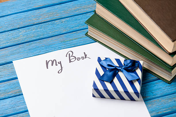 Gift boxes, books and paper with My Book words on blue background