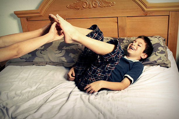 giggling - tickle boy feet pics стоковые фото и изображения.