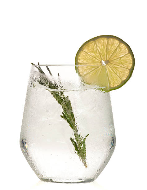 Gin and tonic cocktail with lime over white background. stock photo