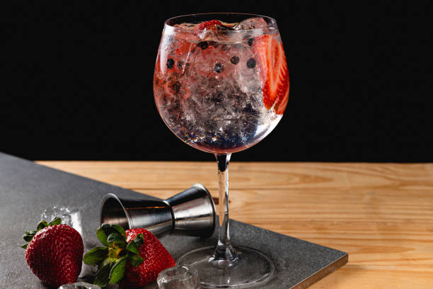 Gin tonic strawberry with juniper stone background in gray color stock photo