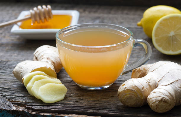 infuso di tè fatto in casa allo zenzero su tavola di legno con limone - zenzero foto e immagini stock