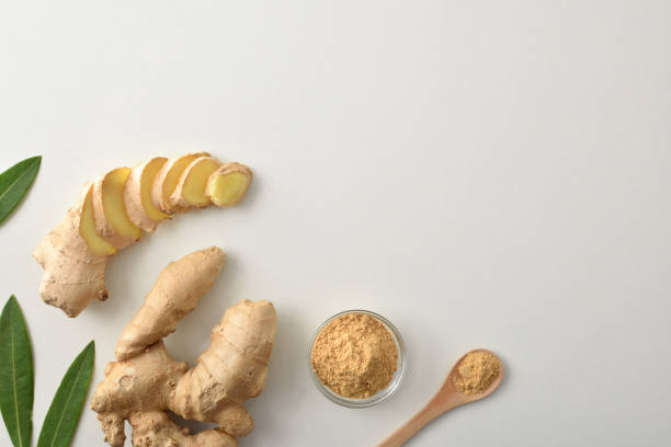 Ginger root and with slices and powder on white table stock photo