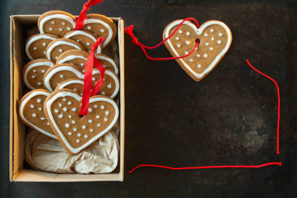 Gingerbread heart shaped cookies with icing in a box on a grunge metal background stock photo