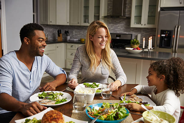 Girl and her mixed race parents dining in their kitchen  dining table stock pictures, royalty-free photos & images