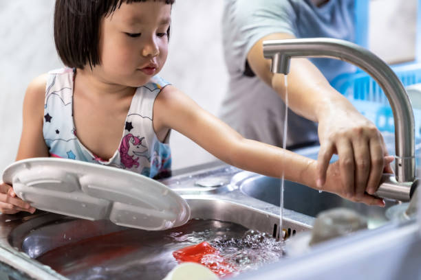 女の子とお母さんは料理、家事をしていました。 - 食器洗い ストックフォトと画像