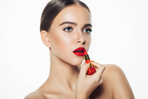 Girl applying red lipstick on her lips Girl applying red lipstick on her lips woman red lipstick stock pictures, royalty-free photos & images