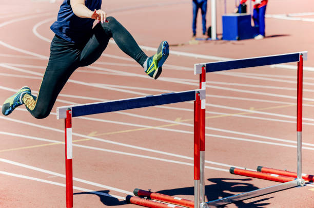 girl athlete run hurdles stock photo