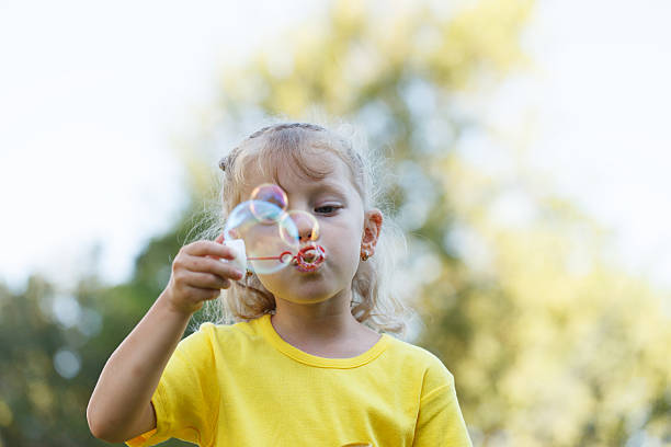 Girl Blowing Bubbles stock photo