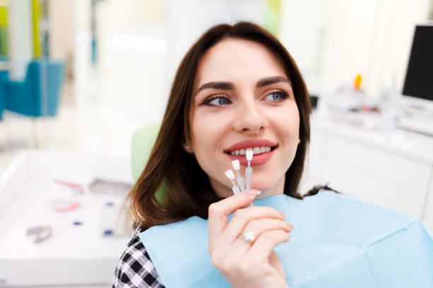 Girl chooses color of veneers at the dentist office Girl chooses color of veneers at the dentist office porcelain stock pictures, royalty-free photos & images