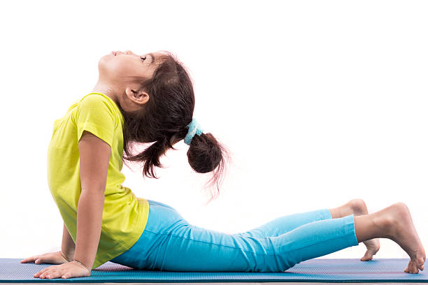girl doing basic yoga girl doing basic yoga in studio yoga for kids stock pictures, royalty-free photos & images