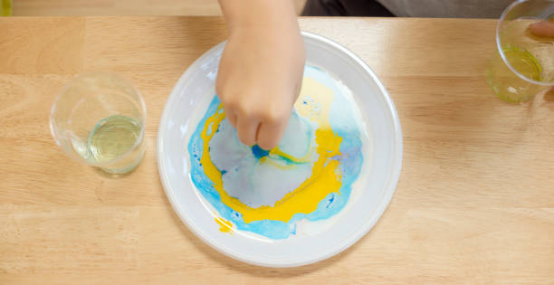 Girl doing colour changing milk experiment in the laboratory stock photo