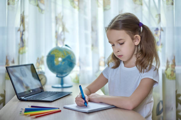 Girl doing homework at home stock photo