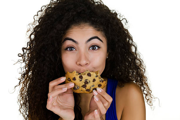 Girl eating a cookie stock photo