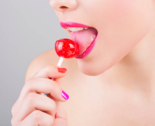 девочка ест a lollipop - women licking balls стоковые фото и изображения.