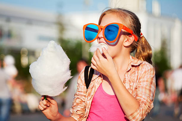Girl eating cotton candy stock photo
